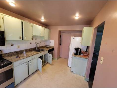 Kitchen before remodeling, with dated cabinets and worn finishes