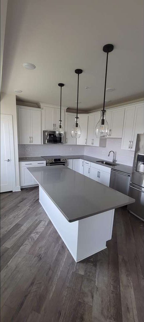 Finished kitchen remodel with white cabinets, quartz island and pendant lighting in Loudoun County, VA
