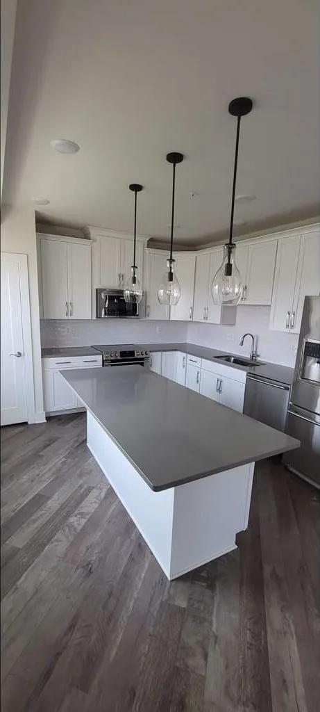 Finished kitchen remodel with white cabinets, quartz island and pendant lighting in Loudoun County, VA